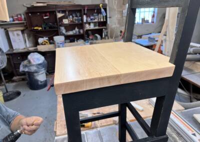 Finishing touches on solid oak barstools with maple seats